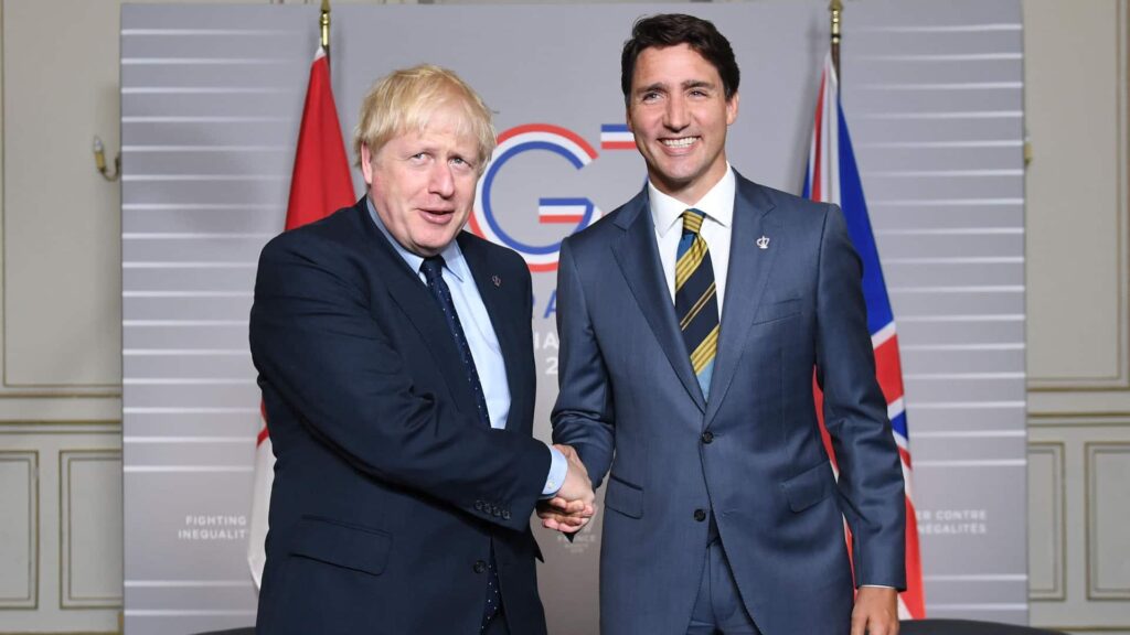 Justin Trudeau and Boris Johnson are handshaking. 